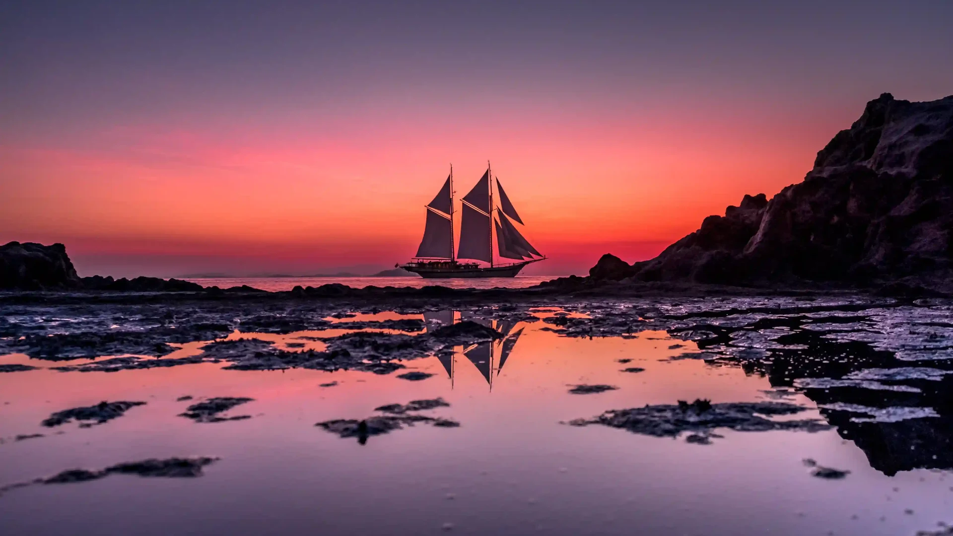 Phinisi yacht under sail at sunset in Komodo National Park