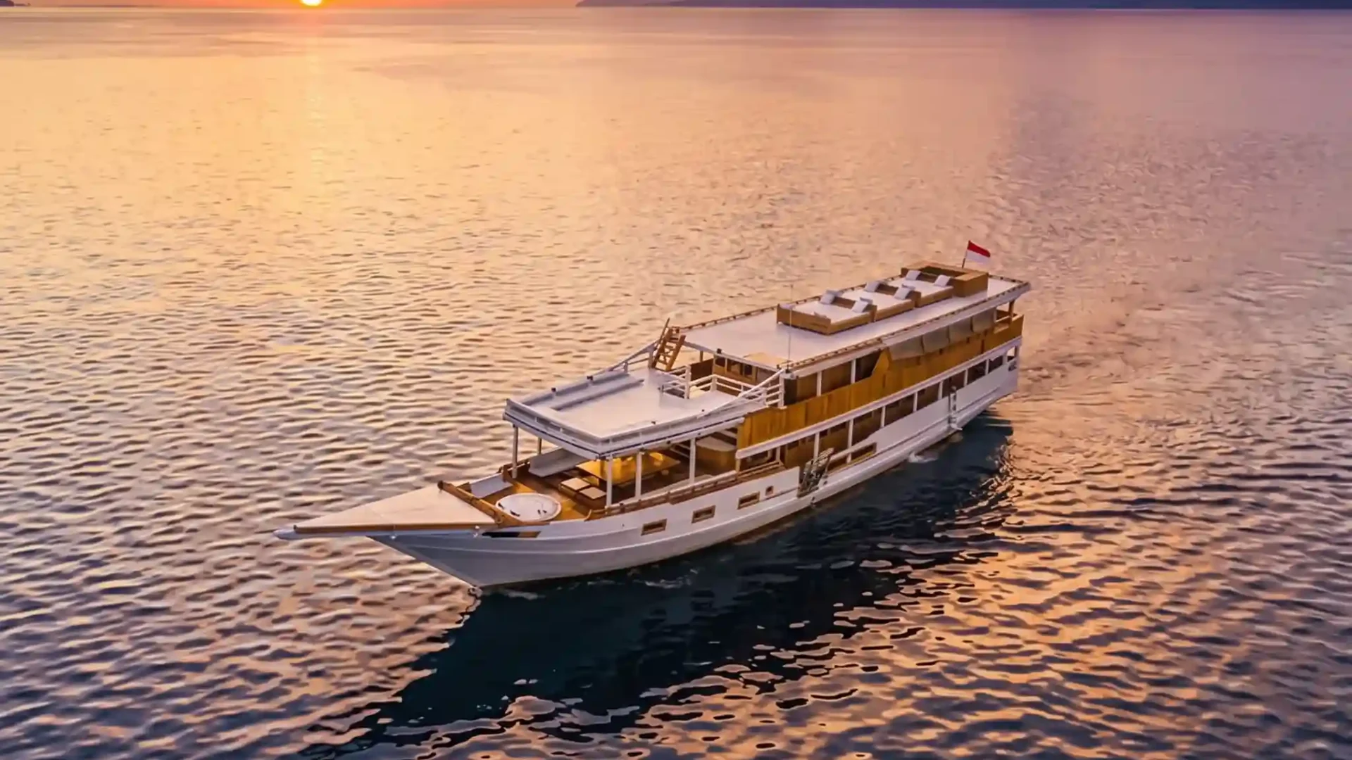 Aerial view of a phinisi sailing at golden hour