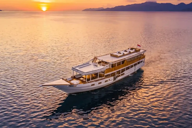 Aerial view of a phinisi sailing at golden hour