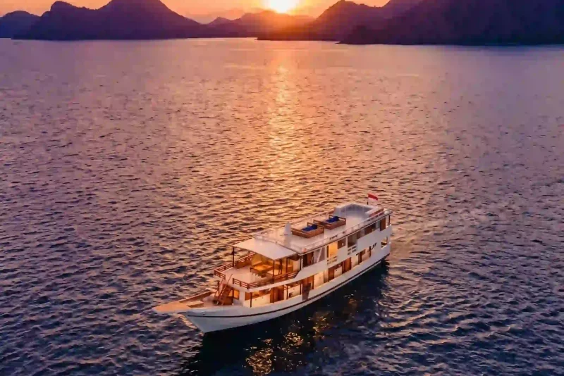 Aerial view of a white yacht at sunset in Komodo