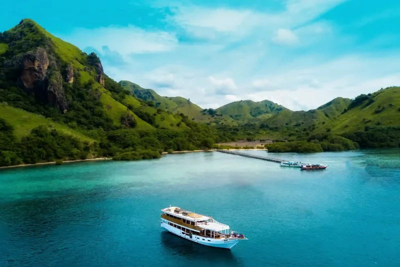 Aerial view of a yacht anchored off a green island in Komodo